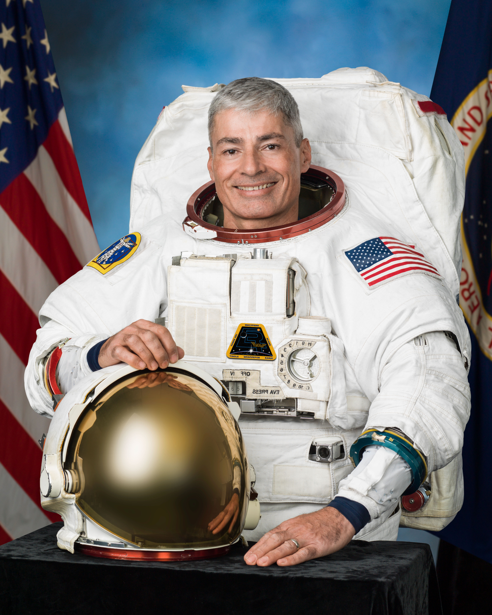 A male astronaut with graying hair dressed in his spacesuit.